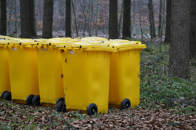 person moving trash bin curb